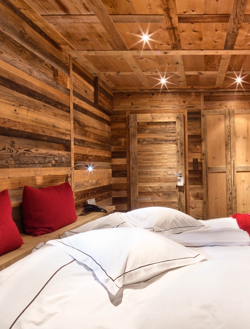 Ein gemütliches Zimmer, in dem alpiner Charme auf den Komfort eines 5-Sterne-Hotels in Crans-Montana trifft.