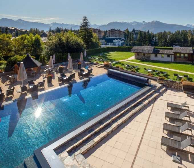 Profitez d'un moment de détente dans notre piscine extérieure face aux paysages emblématiques des Alpes valaisannes.